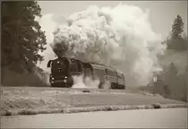 Hier kommt beim Kraftwerk Ruderatshofen die 44 546 mit viel Getöse um die Ecke. Bis Günzach werden dabei wohl noch einige Liter Dampf produziert. Februar 2018. 

Gleiches Bild wie gestern, aber ein Ausschnitt und der Schwarzweißfotografie nachempfunden. Dabei ist ein Gelbfilter, ein dem Wetter entsprechender empfindlicher aber körniger Film und ein wenig Vignette simuliert. Bei diesem Schlechtwetter Grau-in-Grau-Bild habe ich dann auch 
 gemerkt, dass die Schwarzweißfotografen eine gewaltige Palette an Einstellungsmöglichkeiten hatten, wie das Bild am Ende doch noch etwas eindrucksvoller aussah. Wenn man bedenkt, dass man das Ergebnis immer erst viel später sah, sich aber gleich auf Objektiv, Film und Filter festlegen musste, so ziehe ich nachträglich noch einmal den Hut, brauchbare Bilder waren damals durchaus mehr, als Kamera mit einigermaßen passenden Einstellungen hinhalten und abdrücken...