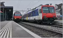 Auf den ersten Blick ein banales Bild: Ein Schnellzug und ein Regionalzug in Arth Goldau.
Doch ein zweiter, genauerer Blick lohnt sich: links wartet die Re 460 006-0 mit dem IR 2324 Erstfeld - Basel auf den Anschluss aus dem Süden und rechts macht der VAE 2579 einen kurzen Halt, ein VAE bei welchem sich ein SOB Triebwagen und der OeBB RABe 207 (UIC 94 85 7560 000-2 ch.oebb) die Traktion teilen. 
Übrigens, auch die SBB Re 460 006-0 kann mit einer Besonderheit aufwarten: auf der Seite der Lok steht aufgemalt und dann übermalt, dass die Lok seit 1992 5'000'000 Kilometer zurückgelegt hat. 
24. Feb. 2018
