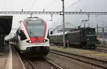 Der SBB/Trenitalia TILO RABe 524 106 erricht im Bild als RE aus Milano C. ausnahmsweise auf Gleis 1 den Bahnhof Erstfeld. 
Grund des Gleiswechsels war der rechts im Bild zu sehende Ae 4/7 10987 mit einem Sonderzug aus Nürnberg/Frankfurt nach Locarno, der das Gleis 4 blockierte. Auf Gleis 3 wird in Kürze sowieso der IR Olten/Zürich HB - Erstfeld ankommen.