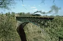 Dampfzug auf der Victoria Falls Bridge.
Aufnahme vom Juli 1997. Soweit ich mich erinnere, war dies ein Dampfzug, der zwischen Bulawayo und Victoria Falls fuhr. Hier ist der Zug auf die Brücke gefahren, um den Passagieren einen guten Ausblick zu gewähren.