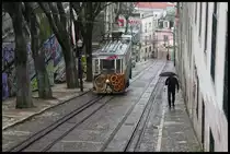 Ein Triebwagen der Standseilbahn in der Taberna da Gloria in Lissabon strebt hier am 19.3.2018 dem Endpunkt der Strecke zu. Im Hintergrund ist noch ein wenig der Gegenwagen zu erkennen, der gerade um eine Hausecke entschwindet.