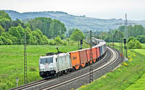 Voll aus dem Gegenlicht kommt morgens des 2.5.2018 die TX Logistik 185 418-3 mit einem Containerzug in Gambach vorüber.