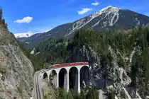 Ge 4/4 II 621 mit einem IR am 25.04.2018 bei Filisur auf dem Landwasserviadukt. 