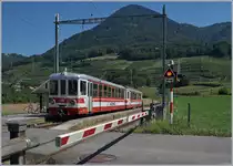 Schranken,  wenn sich Bahn und Strasse kreuzen: In Villy wartet der AOMC Bt 132 und ein schiebender Be 4/4 (beide ex Birsigtalbahn) auf die Abfahrt Richtung Monthey-Ville.
26. August 2016