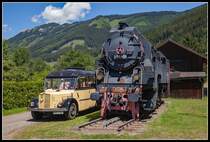 Die 297.401 und ein Nostalgiepostbus stehen 1.07.2018 nebeneinander in Vordernberg Markt.Imposant ist der Größenvergleich der beiden Fahrzeuge.