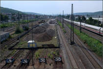 Platz für die Tunnelrampe -

An dieser Stelle in Stuttgart-Untertürkheim entsteht die Tunneleinfahrt vom neuen Abstell- und Wartungsbahnhof aus. Im Hintergrund im Bereich des Kranes werden die Züge im Untergrund verschwinden und dann nach rechts abzutauchen und den Neckar unterfahren. Unterhalb des Neckars vereinigen sich dann kreuzungsfrei diese Tunnelröhren mit den Röhren aus Richtung Obertürkheim.

Der neue Stuttgarter Hauptbahnhof scheint mir als reiner Durchgangsbahnhof konzipiert zu sein. Bei der Größe des Knotens macht es aber Sinn, dass hier auch Züge enden. Diese müssen dann um die geringe Anzahl der Gleise nicht zu blockieren durch die Tunnelstrecken unter dem Stuttgart Osten zu der hier entstehenden Rampe oder durch den Tunnel nach Bad Cannstatt weiterfahren um am Abstellbahnhof zu wenden. Einfach Kopf machen am neuen Bahnhof würde bedingen, dass die Gegenrichtungen gekreuzt werden müssen, was betrieblich störend wäre zumal die Hauptfernverkehrszüge von Mannheim Richtung Ulm die inneren Bahnhofsgleise befahren.

07.08.2018 (M)