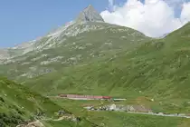 Bergblick auf den 3.096 m hohen Piz Giuv und Talblick auf den in Andermatt gestarteten R 844, der sich kurz nach der Station am Oberalppass auf der Fahrt nach Disentis-Mustér befindet (04.08.2018).