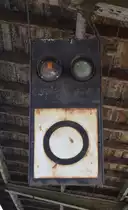 Blick auf einen Vorsignalwiederholer in Blumenberg. Befästigt ist er am Bahnsteigdach, durch den Bogen ist das Hauptsignal nur sehr schlecht bis garnicht sichtbar weshalb hier der Wiederholer notwendig wird. Zudem beachte man rechts oben den Isolator für eine Leitung welche direkt unter dem Bahnsteigdach verläuft.
All das wird jedoch schon in wenigen Jahren Geschichte sein, denn Blumenberg hat schon lange seine besten Zeiten hinter sich. Damals trafen sich hier 4 Strecken. Blumenberg-Wanzleben-Eilsleben, Blumenberg-Schönebeck, sowie Blumenberg-Egeln-Staßfurt wurden zwischen 1999 und 2002 alle samt stillgelegt und so bleibt heute nur noch die Strecke Magdeburg-Halle. Von den ehemals 3 Bahnsteigen und 6 Bahnsteiggleisen ist heute nur noch ein Bahnsteig in Betrieb. Gehalten wird hier nur noch bei Bedarf. Ende des Jahres zum Fahrplanwechsel wird der Halt in Blumenberg aufgegeben. 2020 soll auch die mechanische Signal und Sicherungstechnik durch ein ESTW ersetzt werden und die Strecke auf 120km/h durchgängig ausgebaut werden. Somit dürfte es nach dem Umbau mit dem Bahnhof Blumenberg entgültig zu Ende gehen.

Blumenberg 21.07.2018