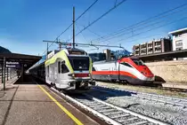 RECHTS:
Ein ETR 500 mit E 404 637-4 am Zugschluss, wartet als FA 8517  FRECCIARGENTO  (Bolzano/Bozen - Bologna Centrale - Firenze Campo di Marte - Roma Termini), auf die Abfahrt.

LINKS:
ETR 170 108 fährt als R 20716 (Merano/Meran - Brennero/Brenner), aus dem Bahnhof aus.

Aufgenommen am 28.9.2018, in Bahnhof Bolzano/Bozen.