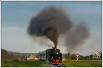 764-411R der Stainzer Bahn am 26.10.2018 in der Katastralgemeinde Herbersdorf. Die Uhren, was die Verkehrszeichen am Bahnübergang betrifft, gehen bei uns nicht erst seit heute anders. Diese Kombination ist in der Straßenverkehrsordnung nicht zu finden. 