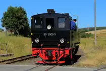 99 5906 hat am 07.07.2018 soeben den Bahnhof Stiege verlassen, den Bahnübergang passiert und fährt nun zum Drehen in die Wendeschleife ein.