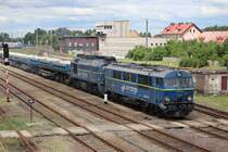 SU46-035 und ST44-1242 ziehen am 30.06.2018 einen Sandzug durch Zagan. Ein interessantes Detail ist der Schutzraum mit Schießscharten, der am rechten Bildrand zu erkennen ist.