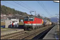 1144 071 fährt am 18.12.2018 mit einem Güterzug durch die Haltestelle St.Georgen am Längsee.