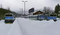 754 078-4 und 754 006-5 am 12.02.2019 im Grenzbahnhof Bayerisch Eisenstein/Zelesna Ruda-Alsbetin. Letztere wird den Bahnhof bald mit dem Schnellzug nach Prag verlassen, während 754 078-4 vor dem Schnellzug nach Pilsen noch bis zum späteren Nachmittag pausieren kann.