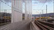 Von der Brücke auf die Brücke -

Eine Stadler-Tango-Tram biegt von der Münchensteinerbrücke auf die aufgeständerte Trasse neben und über den Gleisen des östlichen Bahnhofsvorfeld von Basel SBB in Richtung Haltestelle Peter Merian ab. Auf der Nordseite stehen größer Neubauten mit größeren Glasflächen.

08.03.2019 (M)