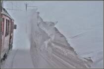 Die Schneeverwehungen am Berninapass übersteigen teilweise die Höhe der RhB Fahrzeuge. R4656 mit ABe 4/4 III 53  Tirano  und 51  Poschiavo  bei Ospizio Bernina. (04.04.2019)