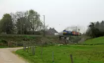 Eine Class 66 PB13 von Beacon-Rail kommt mit viel Dieselpower die Gemmenicher-Rampe hochgefahren aus Richtung Aachen-West mit einem langen MSC-Containerzug aus Germersheim(D) nach Antwerpen-Krommenhoek(B) und fährt gleich in den Gemmenicher-Tunnel hinein.
Aufgenommen von einem Weg in Reinartzkehl. 
Am Nachmittag vom 9.4.2019. 