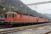 Re 6/6  Prototypen auf dem Abstellgeleise in Bellinzona-San Paolo.
Werden die Re 6/6 mit den Betriebsnummern 11601 „WOLHUSEN“ 1972, 11602 „MORGES“ 1972 sowie 11604 „FAIDO“ 1972 bald zu einem zweiten Leben erweckt oder gar verschrottet? Von der Vorserie bestehend aus den Prototypen 11601 bis 11604 hat bis anhin nur die 11603  „WÄDENSWIL“ 1972 dank RailAdventure überlebt.
Von den vier Ende 1969 bestellten Re 6/6-Lokomotiven, die wesentliche Konstruktionsprizipien  der Re 4/4 II Re 4/4 II aufweisen, wurden die beiden ersten mit geteiltem Kasten (analog RhB Ge 6/6 701-707) ausgeführt.
Beim Bau  der weiteren Re 6/6 11605 bis 11689, die in den Jahren 1975 bis 1980 in Betrieb genommen wurden, hatte man bewusst auf den geteilten  Kasten verzichtet.
Am 11. April 2019 konnten diese Raritäten in einem sehr schlechten Zustand auf einem Bild verewigt werden.
Geschieht nicht doch noch bald ein Wunder, handelt es sich um meine letzten Aufnahmen dieser sehr speziellen Lokomotiven der schweizerischen Bahngeschichte.
Fotostandort zugängliche Wiese, Bildausschnitt Fotoshop.
Foto: Walter Ruetsch    
