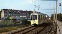 Zum Vergleich mit dem vorherigen Bild eine Aufnahme vom 31.05.1986: Fast an der gleichen Stelle ist der 1937 in Dienst gestellte Niederflurtriebwagen 267 mit dem Beiwagen 316 anlässlich des 90jährigen Jubiläums des Düsseldorfer Hafens unterwegs. Während sich das Gartentor fast unverändert präsentiert, ist von den heute das Bild dominierenden Gebäuden der  Hafen-City  noch nichts zu sehen und auch die Häuser an der Hammer Dorfstraße sind noch nicht renoviert...