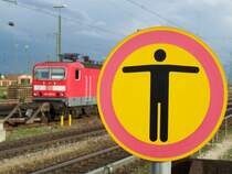 Hier bitte stehen bleiben. Das betreten der Bahnanlage ist f�r Unbefugte verboten. Das soll dieses Schild ausdr�cken, das Schild steht im Bahnhof Ingolstadt, im Hintergrund eine Br.143. Aufgenommen im Juni 2007.