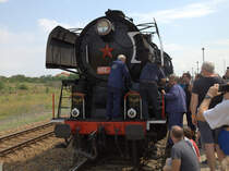 Die Reparatur der Luftpumpe der Lok 556 0506 lockt viele Schaulustige an.
Keiner meckert oder schimpft.In Rudna u Prahu befindet sich gegenüber dem Bahnhof eine Tankstelle, selbige übernimmt die Getränkeversorgung der Reisenden. 22.06.2019 11:14 Uhr , Bahnhof Rudna u Prahu.