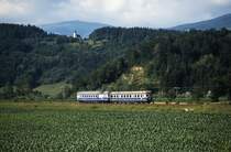 Im Juli 1991 ist 5146 207-5 mit einem Steuerwagen der Reihe 6546 zwischen St. Georgen im Lavanttal und Ettendorf nach Lavamünd unterwegs. Diese Strecke war Bestandteil einer ursprünglich von Zeltweg nach Cilli/Celje führenden Bahn, die aufgrund der Grenzziehung nach dem ersten Weltkrieg an Bedeutung verlor. Bis zur Eröffnung der Jauntalbahn im Jahre 1964 war die Lavamünder Bahn allerdings die einzige Schieneverbindung des Lavanttales mit der Landeshauptstadt Klagenfurt. Zwischen Lavamünd und Bleiburg verkehrten die Züge im Korridorverkehr über jugoslawisches Staatsgebiet. 1997 wurde der Personen- und 2001 der Güterkehr eingestellt. Nachdem Rettungsversuche scheiterten, sind die Schienen 2016 entfernt worden.