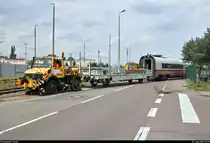 Ein Mercedes-Benz Unimog (Zweiwegefahrzeug) rangiert mit einem Flachwagen und dem Endwagen 411 052-4 von Tz 1152  Travemünde  in der Eisenbahnstraße auf dem Gelände der Maschinenbau und Service GmbH (MSG Ammendorf) in Halle-Ammendorf.
Das im Juli 2006 gegründete Unternehmen beschäftigt sich mit dem Bau und der Reparatur von Schienenfahrzeugen, sowohl für in- als auch ausländische Auftraggeber. Bereits die Gottfried Lindner AG, der VEB Waggonbau Ammendorf sowie zuletzt die Deutsche Waggonbau AG (DWA) waren auf dem Gelände tätig. Mit rund 190 Beschäftigten stellt die MSG den zweitgrößten Industriebetrieb der Stadt Halle (Saale) dar.
[21.6.2019 | 13:39 Uhr]