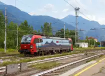 
Die an die SBB Cargo International vermietete Siemens Vectron MS 193 471-0 „Karlsruhe“ (91 80 6193 471-0 D-SIEAG) fährt am 04.08.2019 im  Bahnhof Domodossola aus dem Abstellbereich um einen RAlpin Rola-Zug zu übernehmen.

Die Vectron MS wurde 2018 von Siemens in München unter der Fabriknummer 22313. Eigentümer der Lok ist die  LokRoll AG, eingestellt ist sie über Siemens Mobility in Deutschland und geleast von der SBB Cargo International. Die Wartung der Lokomotiven wurde von der SBB Cargo International im Rahmen eines Full-Service-Vertrages an Siemens vergeben.

SBB Cargo International mit Sitz in Olten, ist eine Gesellschaft der SBB Cargo AG (75 %) und der Hupac AG (25 %).

Im Januar 2017 hat die LokRoll AG einen Vertrag über 18 Vectron Lokomotiven mit Siemens abgeschlossen. Die Lokomotiven sind für 15 Jahre an SBB International verleast. Die Vectron MS haben eine Leistung von 6,4 MW und einer Geschwindigkeit von 160 km/h. Die Fahrzeuge werden in der Schweiz, Deutschland, Österreich und Italieneingesetzt und sind mit ETCS ausgerüstet. Serienmäßig realisierte Länderpakete für grenzenlose Freiheit.

Die Vectron MS Lokomotiven für LokRoll AG sind mit Mehrfachtraktionssteuerung Typ TMC sowie WTB mit österreichischem Fernsteuerkonzept ausgestattet. Die Vectron Lokomotiven ermöglichen in Doppeltraktion eine maximale Gesamtzugkraft von 600 kN ohne jede Einschränkung. 

TECHNISCHE DATEN der Vectron MS:
Spurweite: 1.435 mm
Achsformel: Bo'Bo'
Länge über Puffer: 18.980 mm
Drehzapfenabstand: 9.500 mm
Achsabstand im Drehgestell: 3.000 mm
Breite (über Handstangen): 3.012 mm
Höhe (Panto abgesenkt): 4.248 mm
Raddurchmesser :  1.250 mm (neu) / 1.170 mm (abgenutzt)
Gewicht:  90 t
Spannungssysteme:  15 kV, 16,7 Hz AC / 25 kV, 50 Hz AC / 1,5kV DC / 3 kV DC
Max. Leistung am Rad:  6.400 kW (unter Wechselstrom)
Max. Leistung regenerative Bremse:  6.400 kW
Max. Leistung Widerstandsbremse:  2.600 kW
Anfahrzugskraft:  300 kN
Dauerzugkraft:  250 kN
Höchstgeschwindigkeit: 160 km/h
Elektrische Bremskraft: max. 240 kN
Kraftübertragung: Ritzelhohlwellenantrieb
Kleinster befahrbarer Gleisbogen:  R = 80 m
Volumina Betriebsstoffe: Sandbehälter 4 x 60 l; Wischwasserbehälter 2 x 28 l und Spurkranzschmierung 13 l

Quelle der Daten: Siemens
