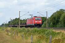 DB Cargo 185 247 mit kurzem Zug aus mit Drehgestellen beladenen Flachwagen in Richtung Osnabrück (Hüde, 08.08.19).