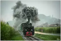 Im strömenden Regen, fährt die CFF Dampflok 764 411R Reghin mit dem Stainzer Flascherlzug von Preding nach Stainz, hier zu sehen bei einer imposanten Ausfahrt aus der Haltestelle Kraubath. 
27.07.2019