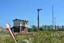 Blick auf das Stellwerk B1 in Barleben sowie das Ausfahrsignal Cäsar und den Bahnübergang. Im Vordergrund liegen 2 alte Formsignale die vor Jahren durch neue ersetzt wurden. 

Barleben 23.07.2019