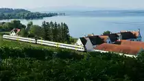 Blick vom Picknickplatz bei der Wallfahrtskirche Birnau auf Schloß Maurach, das Gebäude der ehemaligen Haltestelle Birnau-Maurach und den von Basel Bad Bf kommenden und nach Ulm fahrenden IRE 3041 (16.08.2019).