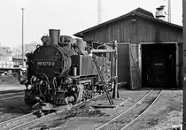 23. Oktober 1982, Schmalspurbahn Radebeul Ost - Radeburg. Vor dem  Radebeuler Lokschuppen nimmt die im Plandienst eingesetzte 99 773 einen guten Schluck Wasser. Im Schuppen ist 99 788 zu erkennen.