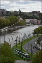 CAF Tram beim Guggenheim Museum am Ufer des Nervión mit der Fussgängerbrücke von Santiago Calatrava. (25.09.2019)