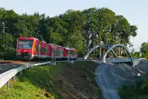 Von Radolfzell kommend werden am 25.08.2019 drei Regio-Shuttle RS1 mit 650 107 am Ende als RB 22789 auf der Fahrt nach Friedrichshafen gleich die im März 2019 eingeschobene neue Eisenbahnbrücke bei Fischbach überfahren, die über eine im Bau befindliche vierspurige Umgehungsstraße führt.