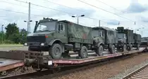 Flachwageneinheit mit abgesenktem Fußboden vom Einsteller TRANSWAGGON mit der Nr. 23 RIV 80 D-TWA 4334 411-4 Laadks 800A Beladen mit drei MB Unimog U 1300 L mit verschiedenen Aufbauten am 07.08.19 in einem Militärzug Bf. Flughafen Berlin Schönefeld. 