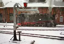 Am 30. Dezember 2002 verschnauft Lok DR 99 735 im Bahnhof Bertsdorf vor dem Lokschuppen.