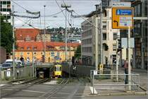 Untertunnelte Innenstadt -

Stuttgart war nach Berlin und Hamburg die erste Stadt, die nach dem Zweiten Weltkrieg begann Tunnelstrecken für den städtischen Nahverkehr zu bauen und die erste die solche Bauwerke für die Straßenbahn erstellte. Der erste U-Straßenbahntunnel ging 1966 am Charlottenplatz in Betrieb, gefolgt von einer weiteren U-Haltestelle ebenfalls am Charlottenplatz 1967. Die Rampen der Strecke von 1966 verschwanden im Zuge der Tunnelverlängerung, lediglich diese 1967 entstande Rampe gibt es heute noch. Sie ist somit die älteste noch in Betrieb befindliche Straßenbahn- bzw. Stadtbahnrampe in Deutschland. 

11.7.2007 (M)