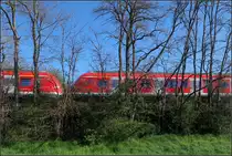 Hinter einem Schleier aus Bäumen -

... reihen sich die Farben von Blau über Rot/Weiß bis Grün.

Ein Zug auf der Linie S2 bei Kernen-Rommelshausen auf der Remsbahn.

11.04.2020 (M)
