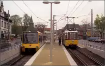 Als die Stuttgarter Stadtbahn noch jung war -

Ein einmalige Situation gab es an der Endhaltestelle der Linie U9 in Hedelfingen, als die Linie 13 noch als Straßenbahn unterwegs war. Hier hielten Stadtbahn und Straßenbahn am selben Bahnsteig gegenüber, für die Straßenbahn war das Gleis am Hochbahnsteig hochgeschottert um den Einstieg in die GT4-Straßenbahn zu ermöglichen. Für die Gegenrichtung wurde auf der Straßenseite ein provisorischer Bahnsteig angelegt, handelt es sich bei GT4 bekanntermaßen um ein Einrichtungsfahrzeug. Um Weichen zu vermeiden wurde das Meterspurgleis in diesem eingleisigen Abschnitt als Gleisverschlinung angelegt. Die Straßenbahnen wendeten links außerhalb des Bildes in in der seitherigen Wendeschleife. Auch dort fand Fahrgastwechsel statt.

Dieser Zustand bestand von 1989 bis 1997.

Scan vom Farbnegativ, 1989

 