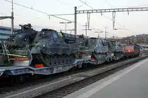 Panzerzug der Pz S 21 im Bahnhof Delémont am frühen Morgen.
Am 16. und 17. April 2020 wurden die Fahrzeuge der Pz Sap Kp 21/5 mit einem Zug von Thun Güterbahnhof nach Bure-Casernes transportiert. Für die Strecke Thun - Biel Rangierbahnhof stand die Re 420 329-5 im Einsatz. 
Nach der Übernachtung im RB Biel wurde für die Weiterfahrt bis Bure-Casernes die stärkere Re 620 007-5  WATTWIL  vorgespannt.
Dieser Zug hatte Biel noch während der Dunkelheit um 06:00h verlassen. 
Die Aufnahmen sind bei Gsteig, in Delémont und Glovelier entstanden.
Transportiert wurden:
4  G Pz Kodiak

5  BPz Büffel

1  Sap Pz 63/05

1  Kdo Pz 63/07 (Fleckenanstrich)

4  Sap Pz 63/05

1  Kdo Pz 63/07 (Fleckenanstrich)

3  Sap Pz 63/05

1  Kdo Pz 63/07 (Fleckenanstrich)

Foto: Walter Ruetsch