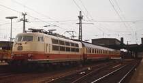 Um 1978 fährt 103 157-4 mit einem IC aus dem Düsseldorfer Hauptbahnhof in Richtung Süden aus. Der Zug führte damals nur die erste Wagenklasse, das Zweiklassensystem bei den IC wurde erst ein Jahr später eingeführt. Im Hintergrund sind noch die alten Hallendächer erkennbar, die ab 1980 durch einen Neubau ersetzt wurden.