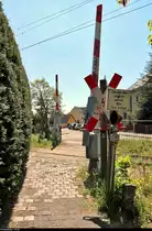 Es war einmal: S-Bahn-Strecke zwischen Halle-Nietleben und -Dölau.

Blick von der Gartenstadt Nietleben auf den ehemaligen Bahnübergang an der Heidestraße, der neben der nur wenige Meter entfernten Eisenbahnüberführung (EÜ) der Querung für Fußgänger und Radfahrer dient. In dessen unmittelbarer Nähe befand sich zu DDR-Zeiten noch die Gaststätte  Zur Grünen Tanne . Konzipiert als Anrufschranke, musste damals eine Taste zum Öffnen gedrückt werden.
Die Anlage befindet sich auf der Bahnstrecke Halle Klaustor–Hettstedt (6800), auch als Halle-Hettstedter Eisenbahn (HHE) bekannt. Bis zum 31.7.2002 fuhr hier noch die heutige S7 von bzw. nach Halle-Trotha.
Aufgenommen im Gegenlicht.
[7.5.2020 | 13:18 Uhr]