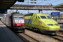 Am 13.04.2007 treffen sich die luxemburgische CFL 4011 der Baureihe 4000 und der TGV 503 im Bahnhof Luxemburg. Der gelbgr�ne TGV weist eine interessante Beklebung auf mit skizzierten Streckenabschnitten, die zu symbolisierten Menschen vervollst�ndigt wurden. Ganz schwach unterlegt wird das Gesamtkunstwerk von den St�dtenamen, die auf der TGV-Strecke liegen. Das Ziel dieses Zuges wird Paris-Est sein.