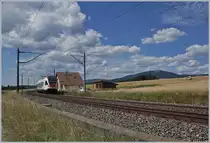 Der SBB RABe 523 021  La Veveyse  als S2 12237 von Vallorbe nach Villeneuve bei einem ehemaligne Bahnübergangs-Wärterhaus in der Sommerlandschaft bei Arnex.

14. Juli 2020