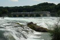 Thurbo S 33 nach Schaffhausen auf der Eisenbahnbr�cke am Rheinfall. F�r die Fahrg�ste ergibt sich ein spektakul�rer Ausblick auf den tosenden Wasserfall, dem gr�ssten Europas mit einer Breite von 150 m und einer H�he von 23 m. Ein Besuch ist nicht nur f�r Eisenbahnfreunde empfehlenswert. 18.7.2007