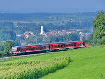 928 584-1, hier Mitte August 2020 auf dem Weg nach Traunstein. Im Hintergrund ist der Ort Waging am See zu sehen.