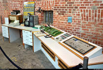 Im Straßenbahnmuseum Stuttgart entsteht aktuell ein weiterer Abschnitt zur Themeninsel  Infrastruktur .

 Das hier gezeigte Exponat ist der Arbeitsplatz eines Stellwerkers aus dem ehemaligen Ortsstellwerk Vaihingen. Es wurde mit Eröffnung der Stadtbahn und der damit verbundenen Automatisierung des Betriebsablaufes unumgänglich.
Der Stellwerker hatte die Aufgabe, den Verknüpfungs- und Umsteigepunkt zwischen den Bus- und Stadtbahnlinien im Bereich der Stadtbahnhaltestelle 'Vaihingen' und des Busbahnhofs zu koordinieren und für einen reibungslosen Betrieb im Schienenverkehr (z.B. durch Stellen von Weichen und Signalen) zu sorgen. 

[29.7.2020 | 13:55 Uhr]

Textquelle: Informationstafel vor Ort