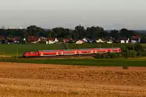 Kurz vor Sonnenuntergang konnte ich am 20. Juli 2020 noch die 111 023 mit ihrem RE 59402 auf der Fahrt nach Ingolstadt HBF bei Walpertshofen im Dachauer Hinterland aufnehmen. Bei guter Fernsicht hat man dort diverse Sehenswürdigkeiten der bayerischen Landeshauptstadt im Bildhintergund. Von Links nach rechts sind dies der BMW-Vierzylinder, das Olympiadorf, der Olympia-Turm, das Stadion und die beiden Türme der Münchener Frauenkirche. Mittig lugt das O2-Hochhaus aus den Bäumen hervor. Rechts erkennt man die Türme des Heizkraftwerks München Süd. Daneben das Wohnheim der Rotkreuzschwestern und die beiden Hochhäuser an der Donnersberger Brücke. 
