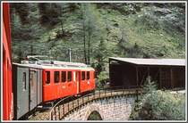 ABe 4/4 mit noch gr�nem zweiachsigen Gep�ckwagen auf Talfahrt oberhalb Cavaglia. (Archiv 06/83)